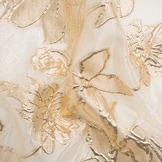 Float through your evening with an air of elegance thanks to this Metallic Gold and Gilded Beige Floating Flowers Luxury Burnout Brocade! Embossed flowers rise in the background and foreground of this luxurious fabric; the more opaque petals outlined in metallic gold grab your attention first while their discrete counterparts hide in the sheer beige backdrop. The face is three-dimensional and grainy, falling with a semi-structured drape—perfect as an elegant overlay for a gown or skirt. If complete opacity is desired, we suggest adding a silk habotai lining (for an added boost of luxury, too!). Organza Gold Flower, Luxury Gold Embroidered Elegant Fabric, Luxury Gold Embroidered Brocade Dupatta, Luxury Gold Embroidered Evening Fabric, Elegant Wedding Fabric With Floral Embroidery, Elegant Party Fabric With Floral Embroidery, Elegant Silk Fabric For Evening, Elegant Evening Silk Fabric, Elegant Organza Fabric For Wedding