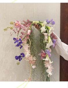 a bunch of flowers hanging from the side of a wall