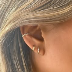 a woman with blonde hair wearing a pair of ear piercings