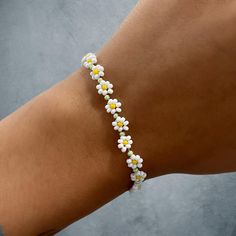 Daisy cabin flower bracelet with silver lobster clasp Adjustable Flower Bracelets With Lobster Clasp, Trendy Beaded Bracelets With Lobster Clasp, Trendy Beaded Bracelet With Flower Charm, Trendy Beaded Bracelets With Flower Charm, Flower Shaped Bracelets For Beach, Trendy Flower Bracelets For Friendship, Adjustable White Bracelet With Flower Decoration, Trendy Flower Charm Bracelets, Trendy Summer Bracelet With Flower Charm