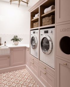 a washer and dryer sitting in a room next to a counter with baskets on it