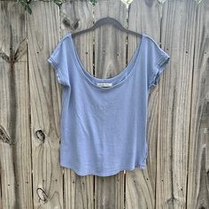 This Is A We The Free By Free People Scoop Neck, Short Sleeve Tea. Size Large. The Color Is A Periwinkle Blue. It Is 100% Cotton And Very Soft Fabric. It Has Raw Edge To-The Sleeves And Neckline. Casual Scoop Neck Tops For Everyday, Cotton Scoop Back Top For Summer, Light Wash Tops For Loungewear, Casual Summer T-shirt With Scoop Back, Spring Loungewear Tops With Scoop Back, Soft-washed Washed Blue Tops For Loungewear, Spring Scoop Back Tops For Loungewear, Scoop Back Tops For Spring Loungewear, Scoop Back Top For Spring Loungewear