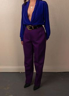 "This classic vintage blouse is made of luxurious purple satin, featuring long sleeves and a gorgeous tuxedo v neck front collar for a timeless look, perfectly styled with trousers or layered and oversized. Fabric: 100 Poly Purple Silky Top: Best fits XS - Large depending on desired fit. This item is pinned. Model is a S, 5 ft 4 in (162.5 cm) x 34/26/36 x US 2/4. Flat Approximate Measurements: Marked Size 12 Length 27 in. Pit To Pit 22 in. Arm Length 24 in. Shoulder to Shoulder 17 in. Made in th Elegant Purple Pants For Party, Chic Purple Evening Bottoms, Elegant Purple Pants, Elegant Purple Pants For Work, Elegant Purple Bottoms For Workwear, Formal Fitted Purple Bottoms, Elegant Purple Pants For Fall, Elegant Purple Bottoms For Party, Elegant Purple Party Bottoms