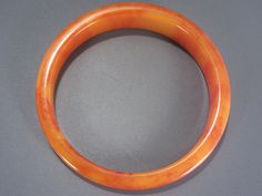 This beautiful vintage Bakelite bangle bracelet is a marmalade orange color and tapers from 1/2 inch to 1/4 inch wide. The bangle has an inner circumference of 7 3/4 inches with a 2 1/2 inch wide inner opening and measures 3 inches wide outer to outer side. In excellent vintage condition. As with all my Bakelite, guaranteed to be authentic and vintage, tested with several reliable methods including simi chrome polish. Bakelite Bangles, Vintage Bakelite, Marmalade, Bangle Bracelet, Orange Color, Bangle Bracelets, 4 Inch, Bangles, Bracelet