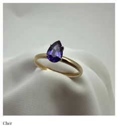 The Cher Ring (Solitaire) This ring was inspired by the one and only, Cher.  Just like it's namesake, it stands alone in all it's proud and unique beauty.  This deep and moody purple Sapphire, pear cut Solitaire radiates strength and indipendence. Product Info: Natural (Untreated) Genuine Violet Purple Sapphire  .84 Ct.  Pear Cut  Solitaire   2mm - 18K Gold Band SI Clairty Please note: All our Sapphire gemstones are genuine and natural, meaning they were mined from the earth and left untreated. Timeless Purple Rings Perfect For Gifts, Timeless Purple Rings As Gifts, Timeless Purple Rings For Gifts, Purple Pear-shaped Ring With Prong Setting, Classic Purple Birthstone Ring, Classic Purple Ring As Gift, Classic Purple Round Band Ring, Classic Purple Rings As Gift, Classic Purple Sapphire Ring With Prong Setting