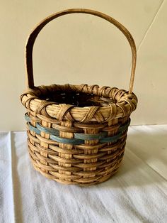 a wicker basket sitting on top of a white cloth