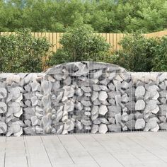 a stone wall with trees in the background