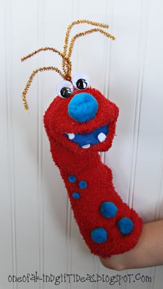 a red stuffed animal hanging from the side of a door with eyes and nose on it