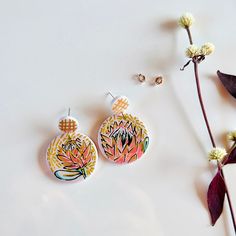 Add a pop of color and playfulness to any outfit with our Handpainted Protea Earrings. These unique earrings feature a fun design on the back and come in two options: with or without black accents. Made with high quality 925 silver stud posts and handcrafted from durable polymer clay. Protea Earrings, Black Accents, Fun Design, Unique Earrings, Silver Studs, Accessories Earrings, Pop Of Color, Color Pop, 925 Silver