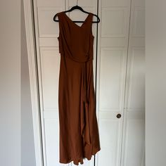 a brown dress hanging on a white door