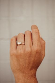 a person's hand with a ring on it