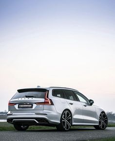 a white car parked on the side of a road next to a body of water