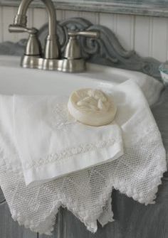 a white towel sitting on top of a sink under a faucet