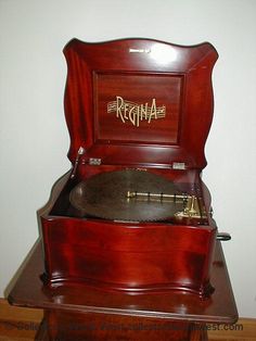 an antique record player sitting on top of a wooden stand