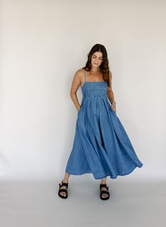 denim adjustable spaghetti straps tie back closure pockets empire waist elastic waistband in back 90% cotton, 10% polyester hand wash cold Abby is 5’6” wearing size small small: 32" bust // 49" length medium: 34" bust // 49" length large: 36" bust // 49" length Midi Maxi Dress, Solid Dress, Solid Tops, Tie Back, Empire Waist, Skirt Pants, Print Tops, Bottoms Pants, Set Dress