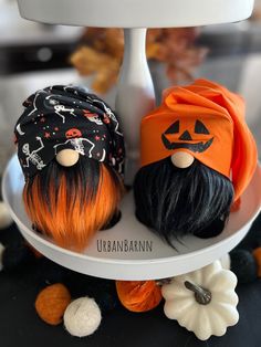 two halloween decorations are sitting on a cake plate