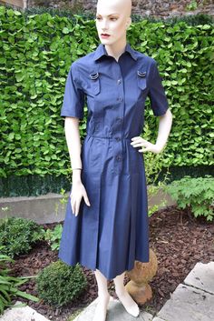 Nice classical navy blue poeppeline cotton shirt dress with short sleeves embellished with a strap motif which begins and ends at back in two inverted pleats, the chest adorned with two metal buckles. Closure by signed buttons. French size 38, American 6, International M. Very good vintage condition. More pictures on my website www.that-little-pink-shop.fr No discount. Free worldwide shipping with tracking and insurance. No returns, including EEC customers. Please contact if you have a problem w Formal Short Sleeve Shirt Dress With Pockets, Classic Fitted Shirt Dress With Pockets, Navy Button-up Workwear Dress, Navy Button-up Dress For Work, Navy Retro Formal Dress, Formal Short Sleeve Buttoned Dress, Classic Navy Dress For Daywear, Formal Short Sleeve Shirt Dress With Button Cuffs, Retro Navy Dress For Formal Occasions