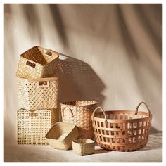 several woven baskets are stacked on top of each other in front of a white background