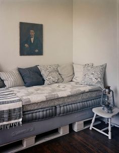 a living room filled with furniture and a painting on the wall above it's headboard