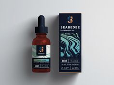 a bottle of seabedee oil next to a cardboard box on a white surface