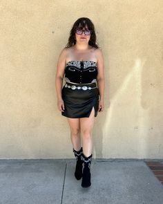 Your next concert outfit or date night staple: our Nessa Black Faux Leather Side Slit Mini Skort! This cute & comfortable black pu mini skort pairs easily with your favorite corset top and boots for a going out look. A side zipper closure helps you slide this style on easily, while woven lining, built-in shorts & stretch pu ensure you can wear it all day & night! A side slit adds a little extra sizzle to this already hot skort. Pinup Cowgirl, Cowgirl Rhinestone, Denim Dress Outfit, Strapless Corset Top, Country Concert Outfits, Rhinestone Cowgirl, Fashion Fall Outfits, Country Concert Outfit, Faux Suede Fabric