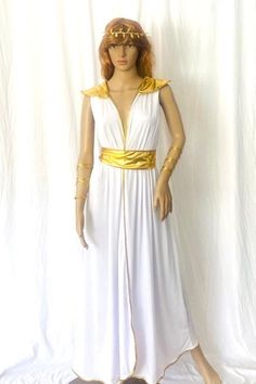 a mannequin wearing a white dress with gold trims and a golden belt