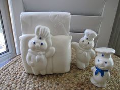 three white ceramic figurines sitting on top of a table