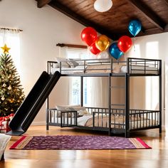 there is a bunk bed with balloons on the ceiling and a slide in front of it