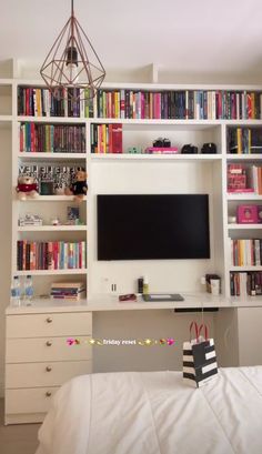 a bedroom with a bed, desk and bookcases on the wall above it