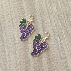 two charms with grapes on them sitting on a table