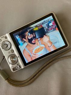 a cell phone with a camera attached to it's side and a video on the screen