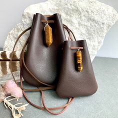 "Vegan Eco Leather Medicine Bag, Shaman Bag or Amulet Pouch to wear around your neck-or hang in your Car! Perfect for Ceremony or for Festival Wear. Dark Chocolate Faux Leather with a Tiger Eye Healing Stone Point. The Large size has a Double Terminated Stone! Unique and Beautiful Gift . A place for things that have Spiritual Meaning for you-like that pretty rock your 3 year old gave you.... Two Choices: Small:3 3/4\"deep 2 3/4\"wide Large:5 1/4\"deep 4\"wide BUY ANY 4 MEDICINE BAGS(VEGAN LEATHE Brown Bag With Dust Bag As A Gift, Brown Coin Purse For Mobile Phone Daily Use, Everyday Portable Brown Pouch, Brown Mobile Phone Bag Coin Purse For Daily Use, Brown Mobile Phone Coin Purse For Daily Use, Brown Everyday Pouch, Leather Coin Purse In Pouch Shape, Portable Leather Coin Purse As Gift, Leather Coin Purse, Portable, Ideal For Gift