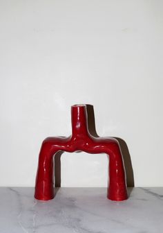 a red faucet sitting on top of a white counter next to a wall