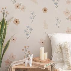 a bedroom with flowers painted on the wall next to a small table and candle holder