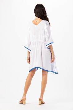 Elevate your beach wardrobe with our Mykonos Mini Dress. This exquisite embroidered coverup allows you to embrace the artistry of seaside fashion. With its intricate detailing and effortless charm, this coverup is sure to make you feel like a beach goddess wherever your adventures take you. Details: 100% Rayon Hand Wash in Cold Water and Lay Flat to Dry Features: Unlined, V-neckline, Embroidered detail, Tassel tie closure to cinch waist for an adjustable fit, Sides drape lower, Billowing short s Vacation V-neck Kaftan With Tassel Ties, V-neck Beach Dress With Tassels For Vacation, Beachwear V-neck Cover-up With Tassels, Blue Boho Dress For Beach Cover-up, Beach Season Dresses With Back Tassel Tie-up, Summer V-neck Tassel Cover-up, Summer V-neck Cover-up With Tassels, Embroidered Beachwear Cover-up For Beach Season, Summer V-neck Embroidered Kaftan