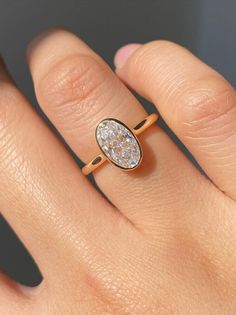 a woman's hand with a yellow gold ring on it and a diamond in the middle