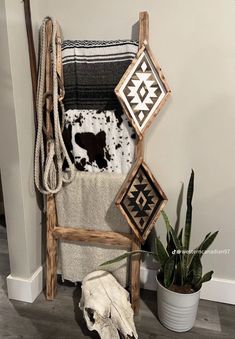 a towel rack with several towels and a cow skull on the floor next to it