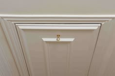 an open door with a handle on the front and side panels in white painted wood