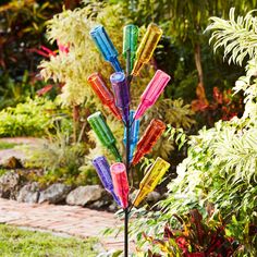 a multicolored umbrella stand in the middle of a garden