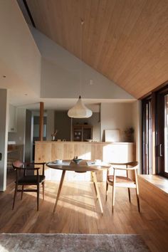 a living room with wooden floors and furniture in the center, along with an area rug on the floor