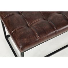 a brown leather bench with metal legs