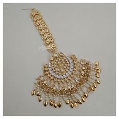 *PRODUCT DETAIL* *Material: Brass *Plating: Gold Plated *Stone: Semi Precious Kundan & Pearls *DIMENSIONS * *Tikka: Weight: 71 gm, Length: 4 Inches, Width: 2.6 Inches, Top Chain Length: 3.12 Inches *Earrings: Weight: 59 gm each, Length: 4.14 Inches, Width: 2.08 Inches *ABOUT PRODUCT* *Beautiful Jadau Kundan Maang Tikka in gold plating and pearl detailing. *Style Tip : A piece to Bring out your Eye for Exclusivity. *DISCLAIMER* *Product & color may slightly vary due to photographic lighti Kundan Tikka With Latkans For Celebration, White Kundan Jhumkas For Wedding, Heavy Kundan Danglers For Wedding, Traditional Gold Chandbali Bridal Accessories, Traditional Gold Bridal Accessories For Celebration, Temple Jewelry Style Kundan Tikka For Celebrations, Kundan Jewelry With Latkans For Wedding, Gold Chandbalis With Stone Work For Weddings, Temple Jewelry Chandbalis With Stone Work For Wedding