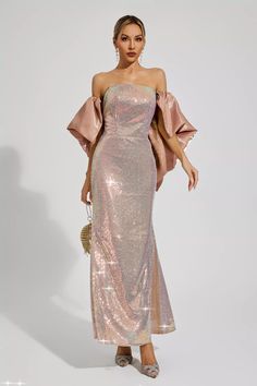 a woman in a pink sequin dress with an off the shoulder top and cape