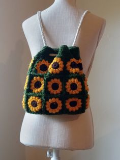 a crocheted sunflower purse on a mannequin