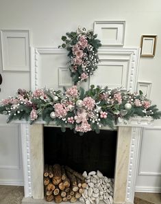 a fireplace decorated with pink and white flowers, greenery and pineconi branches