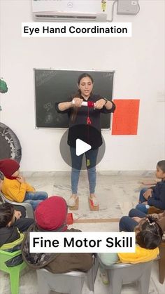 a woman standing in front of a blackboard with writing on it and children sitting around