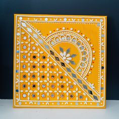 an orange and white decorative tile on the wall with black dots, circles and flowers