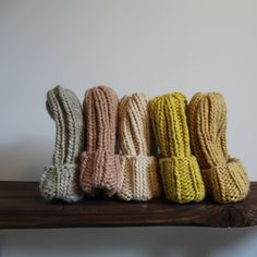 several knitted objects are lined up on a shelf