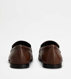 A timeless class characterizes these elegant loafers in smooth leather, with penny bar and leather outsole. Enhanced by Tod's monogram stamped on the front, they perfectly complete both informal outfits and formal combinations. Tods Shoes, Vintage Effect, Brown Loafers, Monogrammed Leather, Italian Luxury, Antique Finish, Luxury Shoes, Metal Chain, Smooth Leather