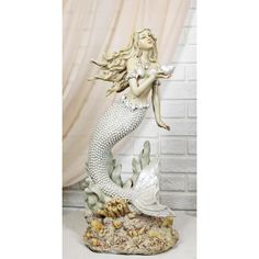 a statue of a mermaid holding a fish